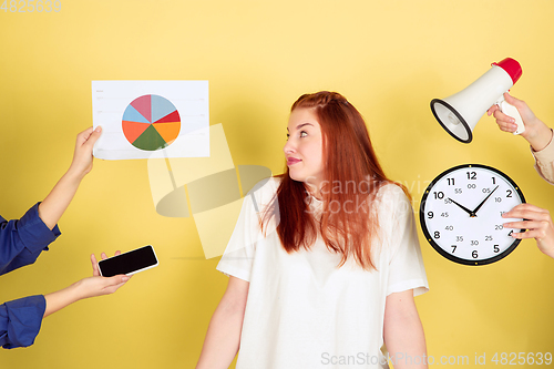 Image of Caucasian young woman\'s portrait on yellow background, too much tasks