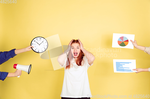 Image of Caucasian young woman\'s portrait on yellow background, too much tasks