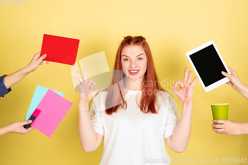 Image of Caucasian young woman\'s portrait on yellow background, too much tasks