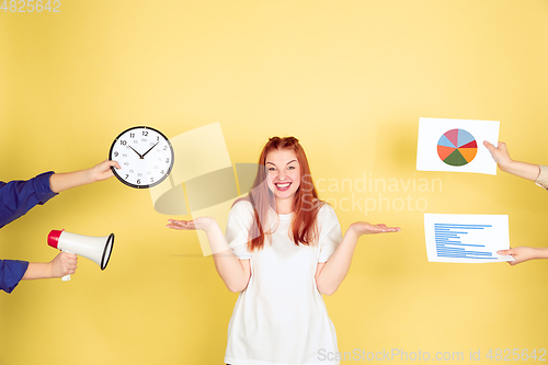 Image of Caucasian young woman\'s portrait on yellow background, too much tasks