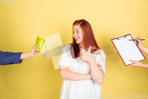 Image of Caucasian young woman\'s portrait on yellow background, too much tasks