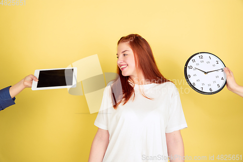 Image of Caucasian young woman\'s portrait on yellow background, too much tasks