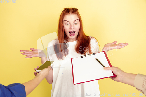 Image of Caucasian young woman\'s portrait on yellow background, too much tasks