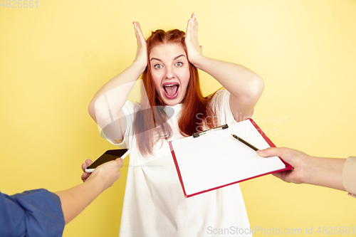 Image of Caucasian young woman\'s portrait on yellow background, too much tasks