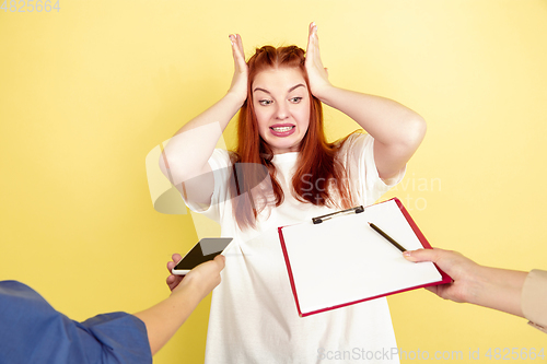 Image of Caucasian young woman\'s portrait on yellow background, too much tasks