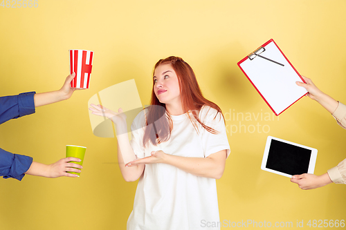 Image of Caucasian young woman\'s portrait on yellow background, too much tasks