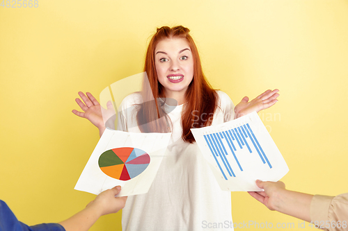 Image of Caucasian young woman\'s portrait on yellow background, too much tasks