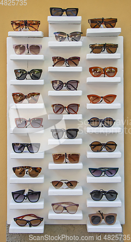 Image of A lot of sunglasses for sale on the stand in the street