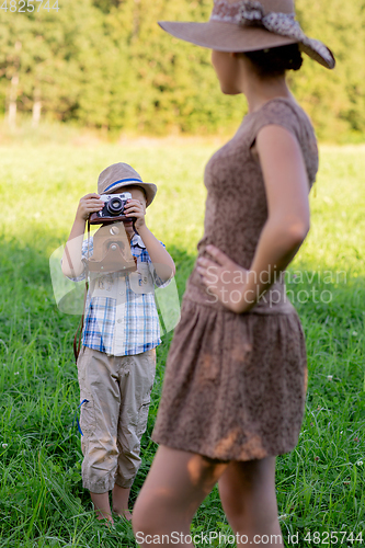Image of handsome little boy with retro camera and girl model