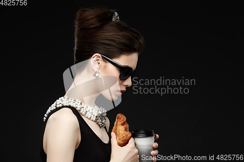 Image of beautiful young woman in retro style with croissant