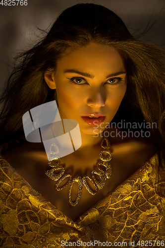 Image of beautiful young woman with necklace in golden light