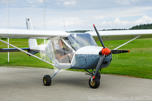 Image of outdoor shot of young man in small plane cockpit