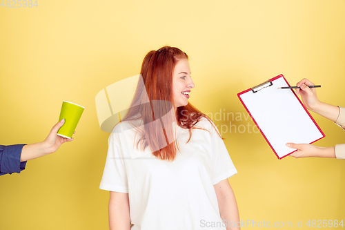 Image of Caucasian young woman\'s portrait on yellow background, too much tasks