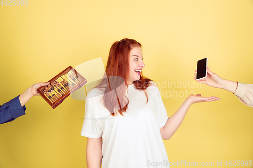 Image of Caucasian young woman\'s portrait on yellow background, too much tasks