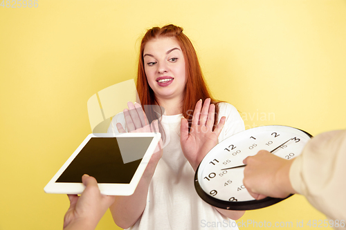 Image of Caucasian young woman\'s portrait on yellow background, too much tasks