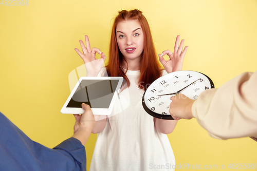 Image of Caucasian young woman\'s portrait on yellow background, too much tasks