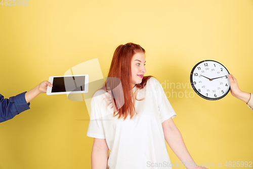 Image of Caucasian young woman\'s portrait on yellow background, too much tasks