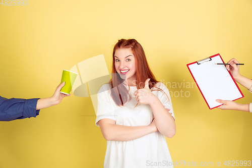 Image of Caucasian young woman\'s portrait on yellow background, too much tasks