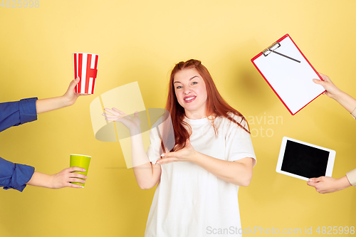 Image of Caucasian young woman\'s portrait on yellow background, too much tasks