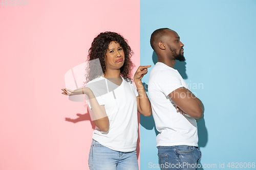 Image of Young emotional man and woman on pink and blue background