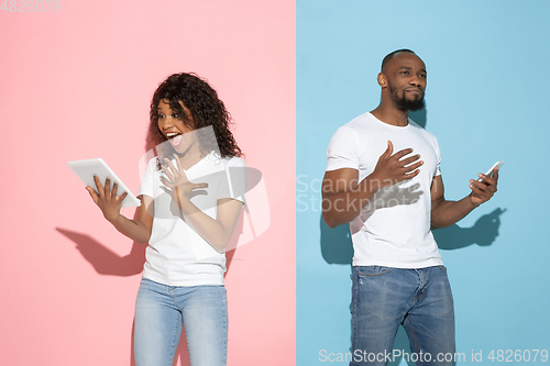 Image of Young emotional man and woman on pink and blue background
