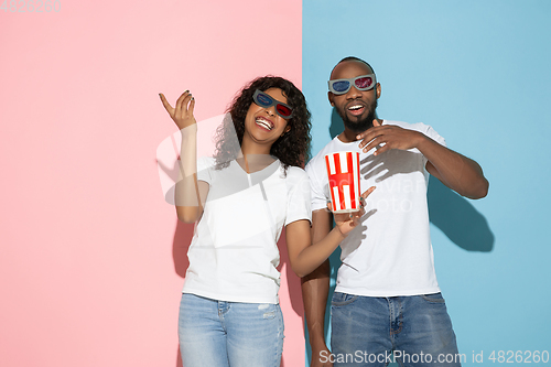 Image of Young emotional man and woman on pink and blue background