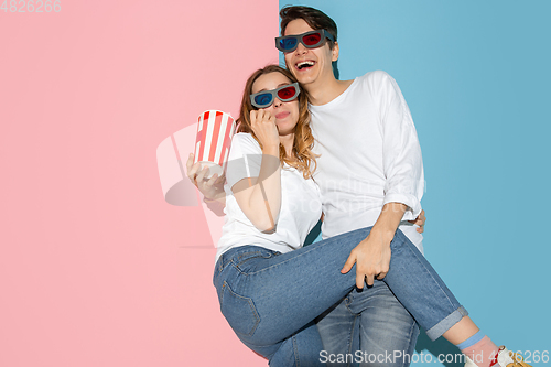 Image of Young emotional man and woman on pink and blue background