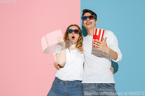 Image of Young emotional man and woman on pink and blue background