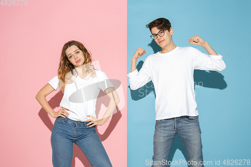 Image of Young emotional man and woman on pink and blue background