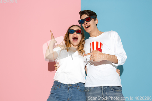 Image of Young emotional man and woman on pink and blue background