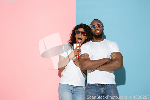 Image of Young emotional man and woman on pink and blue background