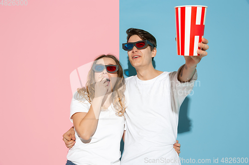Image of Young emotional man and woman on pink and blue background