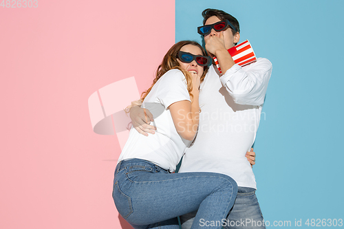 Image of Young emotional man and woman on pink and blue background