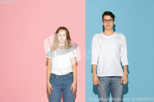 Image of Young emotional man and woman on pink and blue background