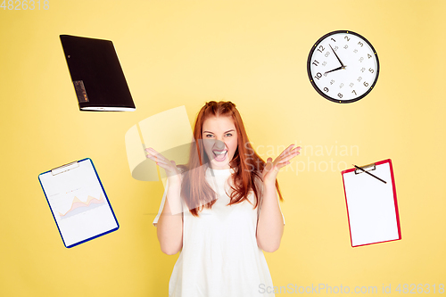 Image of Caucasian young woman\'s portrait on yellow background, too much tasks