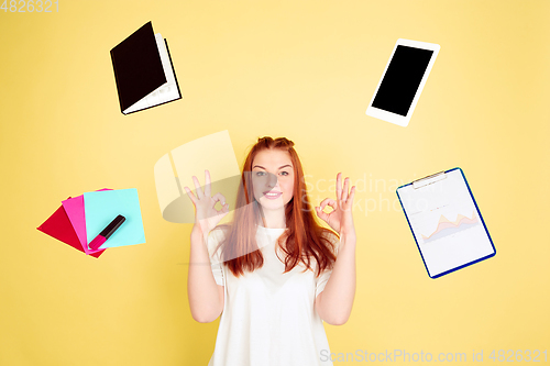 Image of Caucasian young woman\'s portrait on yellow background, too much tasks