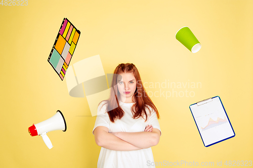Image of Caucasian young woman\'s portrait on yellow background, too much tasks