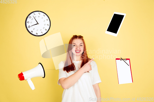 Image of Caucasian young woman\'s portrait on yellow background, too much tasks