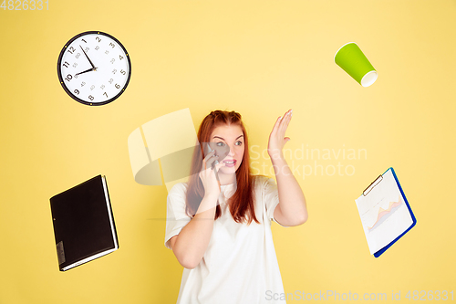 Image of Caucasian young woman\'s portrait on yellow background, too much tasks