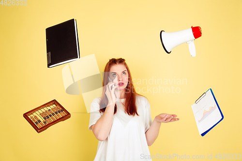 Image of Caucasian young woman\'s portrait on yellow background, too much tasks