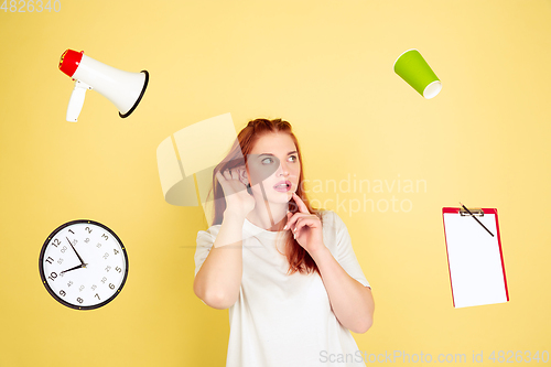 Image of Caucasian young woman\'s portrait on yellow background, too much tasks