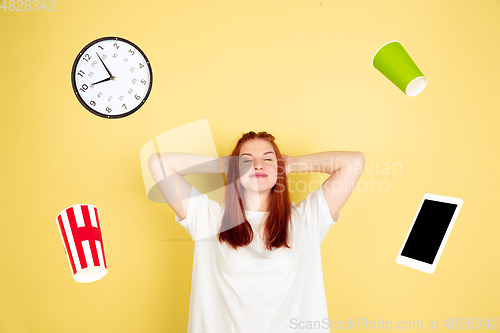 Image of Caucasian young woman\'s portrait on yellow background, too much tasks