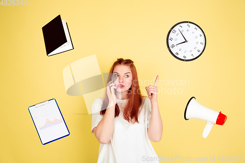 Image of Caucasian young woman\'s portrait on yellow background, too much tasks