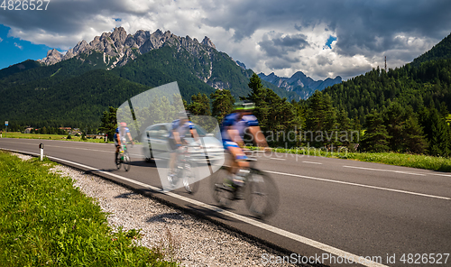 Image of Cyclists riding a bicycle on the road in the background the Dolo