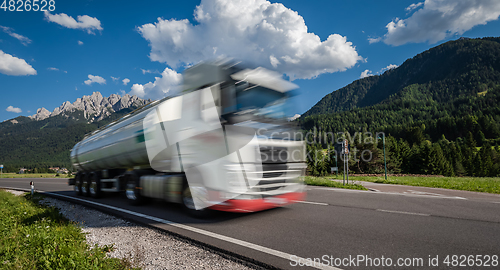 Image of Fuel truck rushes down the highway in the background the Alps. T