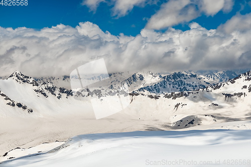 Image of Mountain clouds over beautiful snow-capped peaks of mountains an