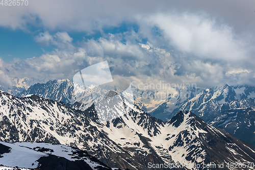 Image of Mountain clouds over beautiful snow-capped peaks of mountains an