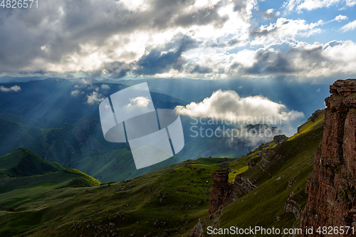 Image of Low clouds over a highland plateau in the rays of sunset. Sunset