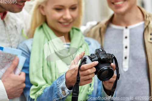 Image of close up of smiling friends with digital camera