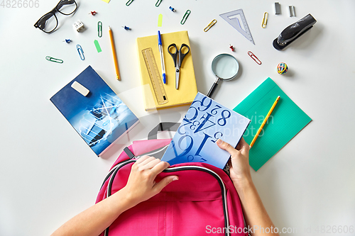 Image of hands with backpack, books and school supplies